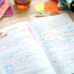 "রঙিন হাইলাইটার, নোটবুক এবং স্টিকি নোট দিয়ে সাজানো পড়াশোনার ডেস্ক, যেখানে গুরুত্বপূর্ণ তথ্য লাল, নীল, সবুজ ও হলুদ রঙে হাইলাইট করা হয়েছে।"